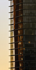 Modern building or glass-enclosed office skyscraper illuminated by the evening sun in Hospitalet.