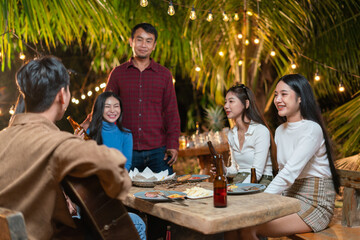 Happy friends cheering and drinking beer at an outdoor birthday party outdoor