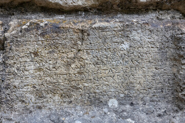 old roman text on the stone wall, Butrint, Albania