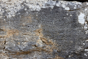 old roman text on the stone wall, Butrint, Albania
