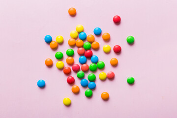 Mixed collection of colorful candy, on colored background. Flat lay, top view. frame of colorful chocolate coated candy