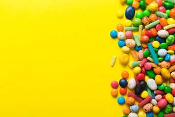 Mixed collection of colorful candy, on colored background. Flat lay, top view. frame of colorful chocolate coated candy