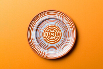 Top view of isolated of colored background empty round brown plate for food. Empty dish with space for your design