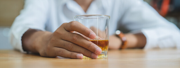 Close up glass of whisky in alcoholic man hand.