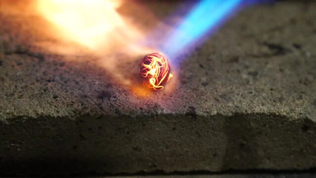 Copper wire melt by gas burner. Man in a metal workshop using a blow torch. Forge workshop. Smithy manual production. Gas furnace for heating metal. The blacksmith makes cooper products. Slow motion.