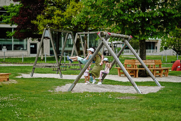 Obraz na płótnie Canvas Mother with kids swinging in playground at Hallstatt, Austria.