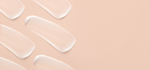 cosmetic smears of creamy texture on a beige background