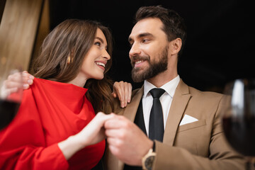 low angle view of cheerful couple holding hands during celebration on valentines day