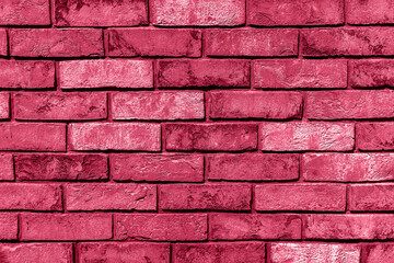 Sunlit weathered brick wall toned in trendy magenta color of year 2023. Brick texture for your design. Copy space. Wallpaper design.