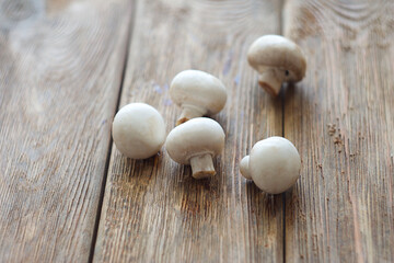Mushrooms champignons lie on a wooden table. This is the day
