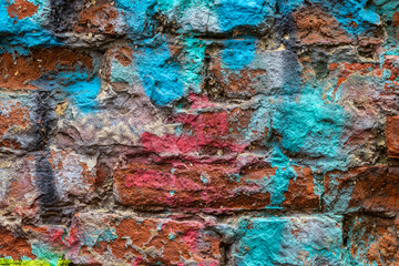 Brick wall with multi-colored paint close-up. Background brick creative
