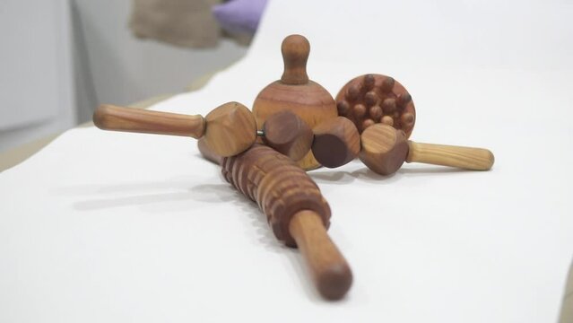 Close up of a wooden massager set used for manual deep tissue massage therapy laid out on a massage bed table in a physiotherapy clinic