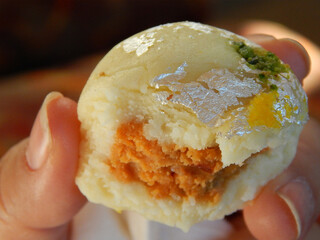 Closeup Indian Sweet Dessert Bite in a woman's hand
