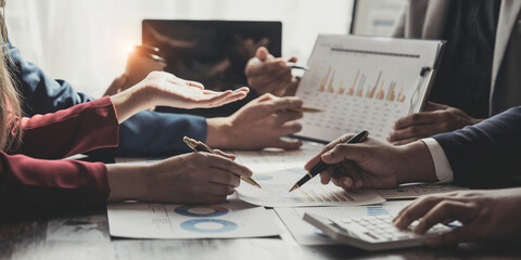 Business People Meeting using laptop computer,calculator,notebook,stock market chart paper for analysis Plans to improve quality next month. Conference Discussion Corporate Concept.