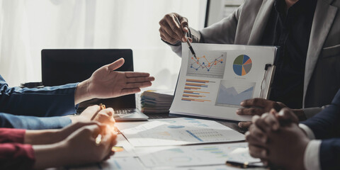 Business People Meeting using laptop computer,calculator,notebook,stock market chart paper for analysis Plans to improve quality next month. Conference Discussion Corporate Concept.