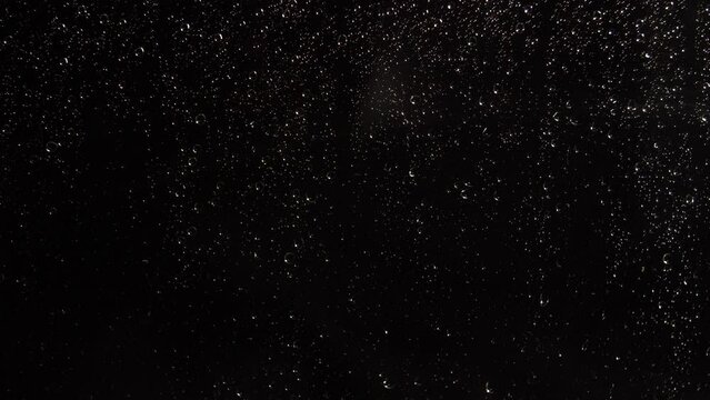 Drops of water run down the glass. Night rain
