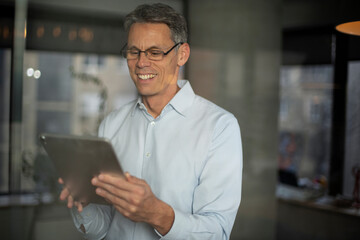 Fototapeta na wymiar Portrait of businessman in office. Man using digital tablet. Businessman having video call.