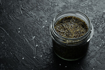 Beluga black caviar. High-quality caviar. On a black background. Macro photo. Free space for text.