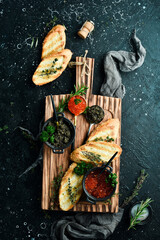Caviar. Black and red premium caviar and toast bread for making sandwiches. On a wooden board....