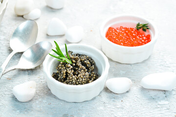 Macro photo. Red and black caviar in a bowl. On a gray concrete photo. Premium quality caviar.
