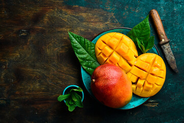 Mango background. Fresh delicious sweet mangoes in a plate. Top view. Copy space.