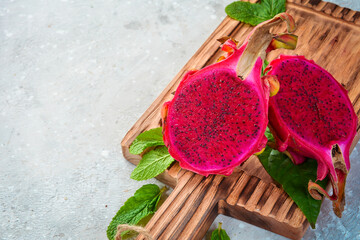 Ripe fruit Red dragon fruit. Tropical fruits. On a gray concrete background. Top view.