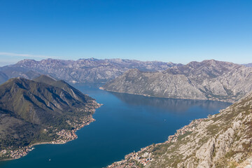 Fototapeta premium Panoramic view from Pestingrad (Derinski Vrh) of Kotor bay in sunny summer, Adriatic Mediterranean Sea, Montenegro, Balkan Peninsula, Europe. Fjord winding along coastal towns. Lovcen, Orjen mountains