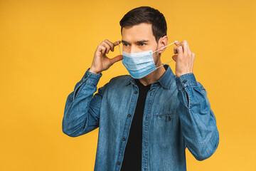 Protection against contagious disease, coronavirus, covid-19. Man wearing hygienic mask to prevent infection, airborne respiratory illness such as flu, 2019-nCoV. Isolated over yellow background