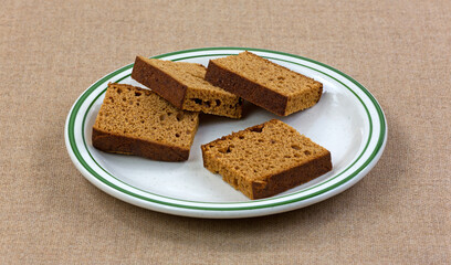 Slices of Dutch honey cake on a plate atop a burlap tablecloth.