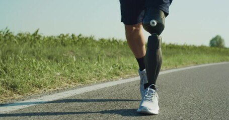 Sporty Person With Disability Walking on The Side of the Road. A Man With Bionic Limb Prosthesis Resting in The Middle of Morning Run. Close Up on Technologically Advanced Artificial Leg. - Powered by Adobe