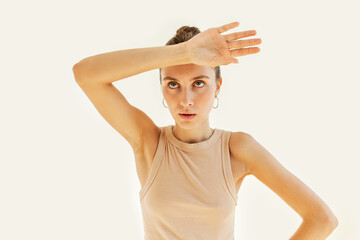 Studio image of beautiful caucasian female wiping forehead with hand making phew gesture,...