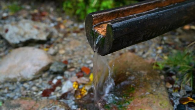 clean water flowing from a wooden gutter on a tourist trail
