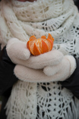 Fototapeta na wymiar peeled tangerine in gloved hands