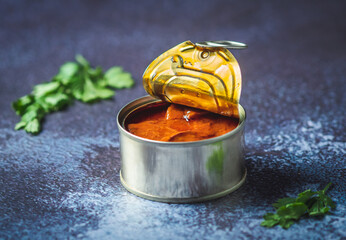 Canned octopus with american sauce open on a dark blue table with parsley. Ready for eat. 