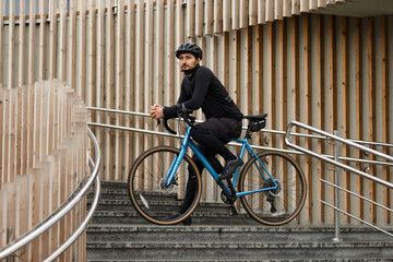 A cyclist on a gravel bike, resting before a race in the city.