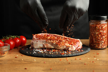 Sprinkle a fresh juicy piece of raw beef with salt and spices, the cook marinates the steak.