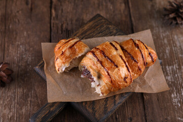 Croissant with chocolate on a wooden board on a wooden board
