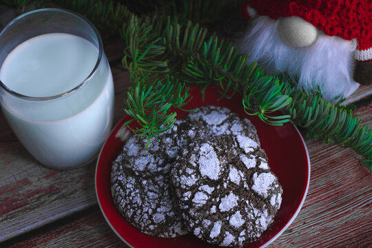 Crackled chocolate cookies on a plate for Christmas. Gnome in background and glass with milk