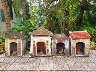 Worship to the ancestors in Vietnam street. Culture and religion of Asia. Small stone temples with...