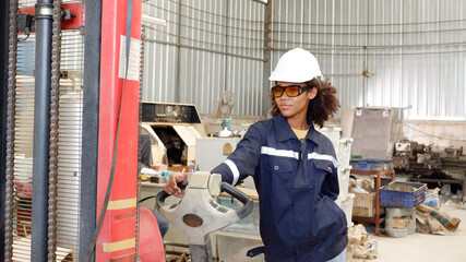 Engineer on forklift inside industrial factory.