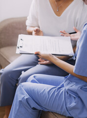 Homecare nursing service and elderly people cardiology healthcare. Close up of young hispanic female doctor nurse check mature caucasian man patient heartbeat using stethoscope during visit