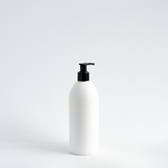 White unbranded bottle with a black dispenser isolated on white background. cosmetic packaging mockup with copy space. Bottle for a shower, gel, soap.