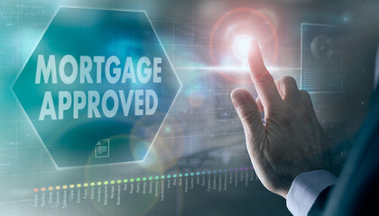 A businessman controlling a futuristic display with a Mortgage Approved business concept on it.