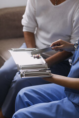 Homecare nursing service and elderly people cardiology healthcare. Close up of young hispanic female doctor nurse check mature caucasian man patient heartbeat using stethoscope during visit