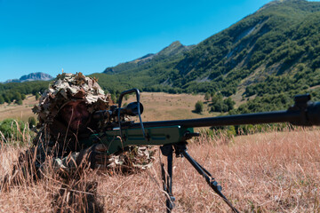 Naklejka premium Army soldier holding sniper rifle with scope and aiming in forest. War, army, technology and people concept