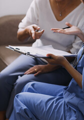 Homecare nursing service and elderly people cardiology healthcare. Close up of young hispanic female doctor nurse check mature caucasian man patient heartbeat using stethoscope during visit