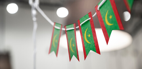 A garland of Mauritania national flags on an abstract blurred background