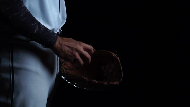 A baseball player pitcher with his baseball and baseball gloves