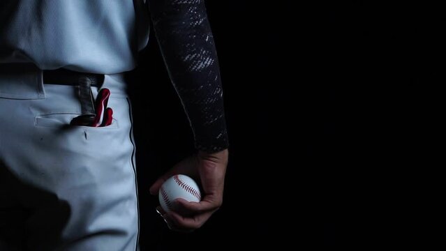 A baseball player pitcher with his baseball and baseball gloves