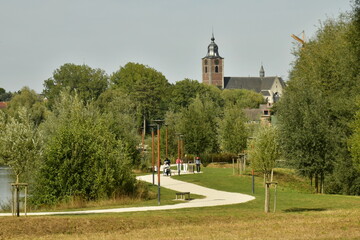 Le clocher de l'&eacute;glise Saint Etienne &eacute;mergeant de la nature luxuriante du parc du Paradis &agrave; Braine l'Alleud au Brabant Wallon 